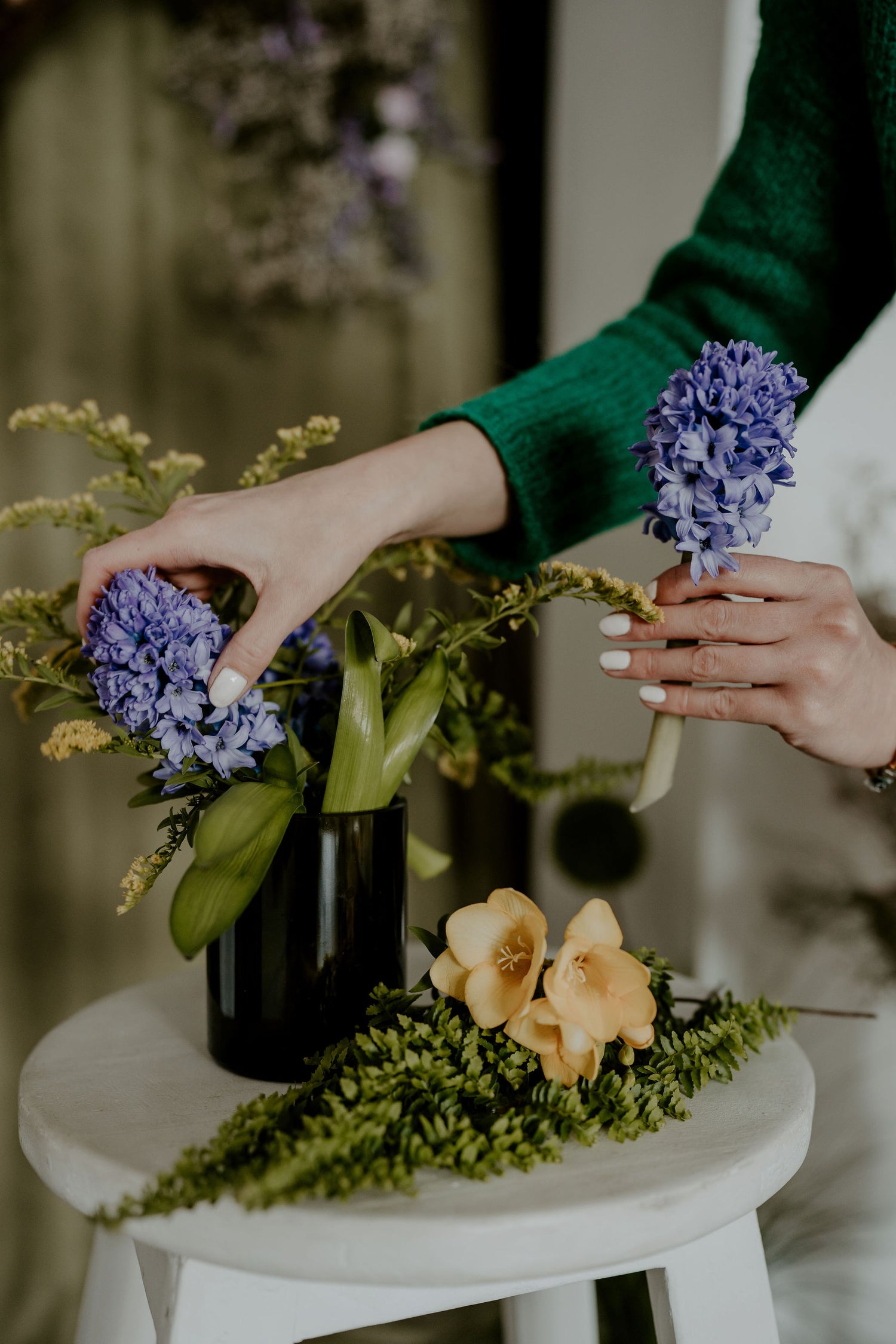 Rearanging a beautiful flower bouquet in a vase made from upcycled wine bottle